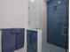 Modern bathroom with blue tile shower and glass enclosure at 112 Mangrove Ave, Anna Maria, FL 34216