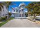 Three-story beach home with colorful exterior and palm trees at 112 Mangrove Ave, Anna Maria, FL 34216