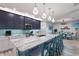 Stylish kitchen boasting dark blue cabinetry and a spacious marble island at 112 Mangrove Ave, Anna Maria, FL 34216