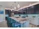 Modern kitchen with marble island, stainless steel appliances, and teal backsplash at 112 Mangrove Ave, Anna Maria, FL 34216