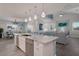 Open concept kitchen with large island, stainless steel appliances and breakfast bar at 112 Mangrove Ave, Anna Maria, FL 34216