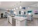 Modern kitchen with white cabinetry, marble countertops, and island seating at 112 Mangrove Ave, Anna Maria, FL 34216