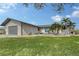 Single-story home with gray siding, attached garage, and landscaped lawn at 128 Sinclair Se St, Port Charlotte, FL 33952