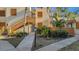 Exterior view of condo building showcasing landscaping and walkway at 144 Wild Palm Dr, Bradenton, FL 34210