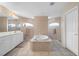 Bathroom boasts a large soaking tub, double vanity, and tile flooring at 1577 Taggard Rd, North Port, FL 34288