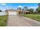 Tan house with white garage door and driveway at 1577 Taggard Rd, North Port, FL 34288