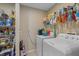 Bright laundry room with washer, dryer, and shelving at 1577 Taggard Rd, North Port, FL 34288
