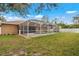 Backyard view of home with screened pool at 1577 Taggard Rd, North Port, FL 34288
