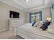 Main bedroom with king bed, TV, and sliding doors to backyard at 16203 Tradewind Ter, Lakewood Ranch, FL 34211