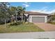 Single-story home with gray siding, tile roof, and a two-car garage at 17530 Northwood Pl, Bradenton, FL 34202