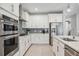 Modern kitchen with white cabinets, stainless steel appliances, and gray tile backsplash at 17530 Northwood Pl, Bradenton, FL 34202