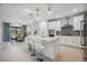 Modern kitchen with white cabinets, gray backsplash, and a large kitchen island at 17530 Northwood Pl, Bradenton, FL 34202
