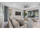 Spacious living room with large windows, comfortable seating, and a modern TV stand at 17530 Northwood Pl, Bradenton, FL 34202