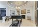 Formal music room with a black grand piano and ornate chandelier at 22623 Morning Glory Cir, Bradenton, FL 34202