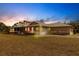 House exterior at dusk, showcasing architectural details and landscaping at 27425 Jones Loop Rd, Punta Gorda, FL 33982