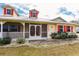 Front porch with red door, white railings and landscaping at 27425 Jones Loop Rd, Punta Gorda, FL 33982