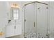 Bathroom featuring a walk-in shower, white cabinets, and gold accents at 3015 Avenue E, Holmes Beach, FL 34217