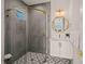 Stylish bathroom with gray hexagonal tile shower, white vanity, and gold fixtures at 3015 Avenue E, Holmes Beach, FL 34217