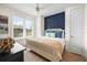 Bright bedroom featuring a king-size bed, navy accent wall, and gold ceiling fan at 3015 Avenue E, Holmes Beach, FL 34217