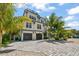 Two-story home with a white exterior, dark gray roof, and a large driveway at 3015 Avenue E, Holmes Beach, FL 34217