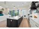 Island kitchen with white cabinets, quartz countertops and a spacious layout at 3015 Avenue E, Holmes Beach, FL 34217