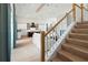 Elegant staircase with wood treads and white railing overlooking the kitchen and living area at 3015 Avenue E, Holmes Beach, FL 34217