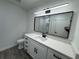 Modern bathroom with white vanity, black accents, and gray floors at 3517 Bahia Vista St, Sarasota, FL 34239