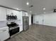Modern kitchen features white cabinets, stainless steel appliances, and gray floors at 3517 Bahia Vista St, Sarasota, FL 34239
