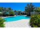 Resort-style pool with palm trees and building in background at 395 Aruba Cir # 302, Bradenton, FL 34209