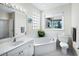 Bathroom with corner bathtub, toilet, and vanity with sink at 409 Casey Key Rd, Nokomis, FL 34275