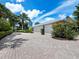 Long paved driveway leading to a two-car garage, surrounded by lush landscaping at 409 Casey Key Rd, Nokomis, FL 34275