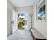 Bright entryway with tiled floor, coat rack, and bench at 409 Casey Key Rd, Nokomis, FL 34275