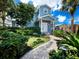 Charming two-story house with a walkway, landscaping, and a blue exterior at 409 Casey Key Rd, Nokomis, FL 34275