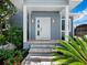 White front door entrance with brick steps, under a covered porch at 409 Casey Key Rd, Nokomis, FL 34275