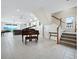 Open living area with tiled floor, grand piano, and staircase at 409 Casey Key Rd, Nokomis, FL 34275