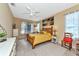Bright bedroom with a wooden bed, yellow bedding, and large windows at 4111 Hemingway Dr, Venice, FL 34293