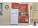 Kitchen with white refrigerator, wood cabinets, and granite countertops at 4111 Hemingway Dr, Venice, FL 34293