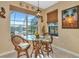 Bright kitchen nook features glass-top table, wicker chairs, and a view at 4111 Hemingway Dr, Venice, FL 34293