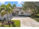 Front view of a house with palm trees, a three-car garage and a large driveway at 4214 Palacio Dr, Sarasota, FL 34238
