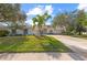 House with a large lawn, palm trees, and a three-car garage at 4214 Palacio Dr, Sarasota, FL 34238