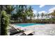 Long pool featuring lounge chairs on a patio with lush palms and greenery at 435 S Gulfstream Ave # 604, Sarasota, FL 34236