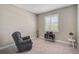 Cozy bedroom with a recliner, window with shutters, and a small vintage record player at 5282 Grove Mill Loop, Bradenton, FL 34211