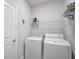 Bright laundry room with washer, dryer, and overhead shelving at 5282 Grove Mill Loop, Bradenton, FL 34211