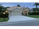 Beige house with three-car garage and manicured lawn at 644 Rivendell Blvd, Osprey, FL 34229