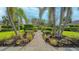 Brick pathway lined with palm trees and shrubs at 644 Rivendell Blvd, Osprey, FL 34229