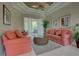 Relaxing living room with coral striped sofas and wicker coffee table at 644 Rivendell Blvd, Osprey, FL 34229