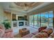 Living room features a fireplace, sectional sofa, and sliding doors leading to a tranquil patio at 644 Rivendell Blvd, Osprey, FL 34229