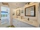 Double vanity bathroom with white cabinets and a view of a bedroom at 653 Cedars Ct, Longboat Key, FL 34228