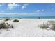 Beach access with white sand and dunes, offering privacy and tranquility at 653 Cedars Ct, Longboat Key, FL 34228