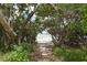 Scenic nature trail leads to a secluded beach through lush foliage at 653 Cedars Ct, Longboat Key, FL 34228